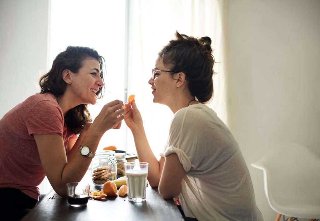 A female couple enjoying time together over a snack